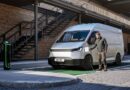 Nowy srebrny Ford Transit City furgon w ruchu miejskim, przy ładowarce